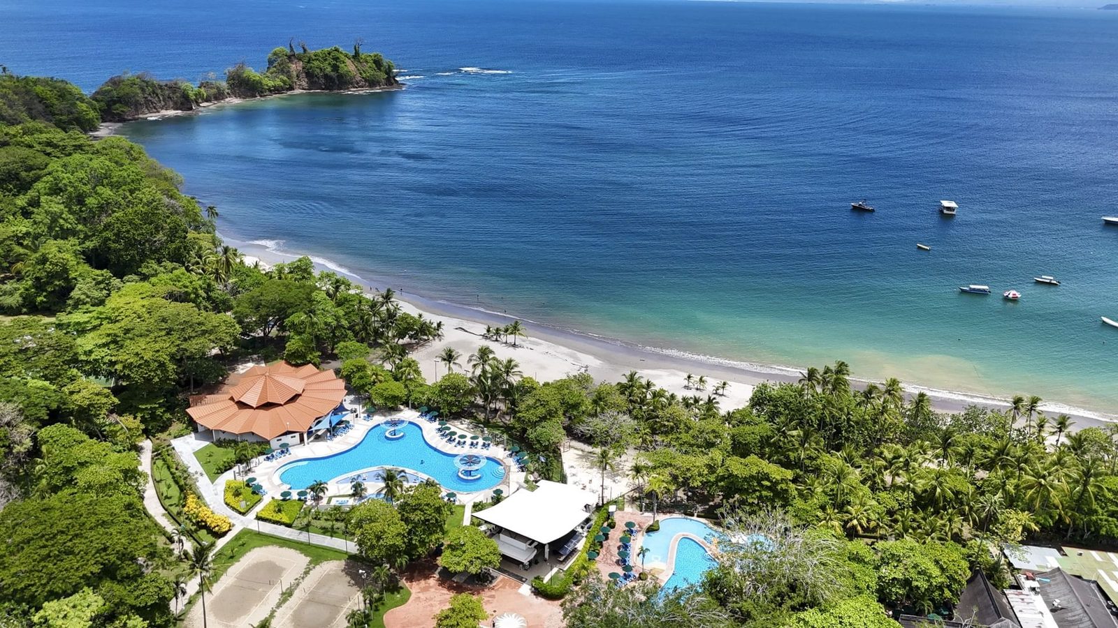 Vista aérea del Hotel Punta Leona con sus piscinas, el bosque y la costa del Pacífico Central