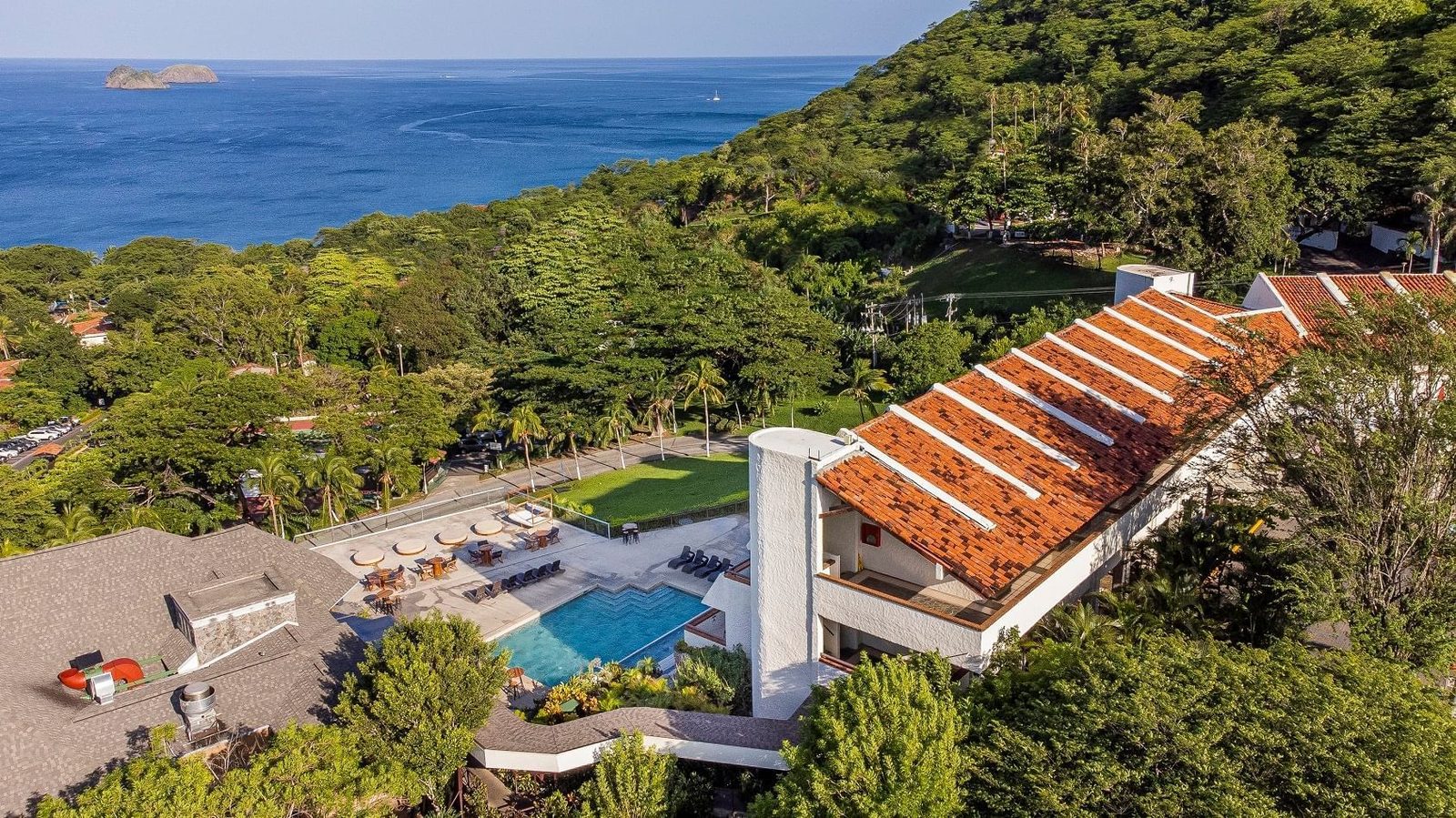 Vista aérea de Villas Sol Hotel & Beach Resort sobre la ladera con el Pacífico de fondo